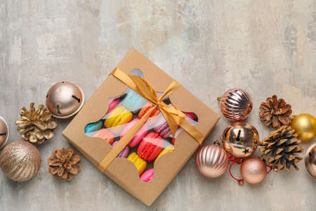 Christmas decor with tasty macarons in gift box on gray backgroundの写真素材