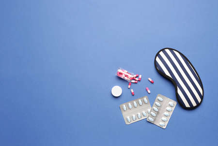 Sleep mask and pills on color backgroundの写真素材