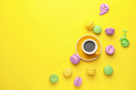 Tasty macarons with cup of coffee on color backgroundの写真素材