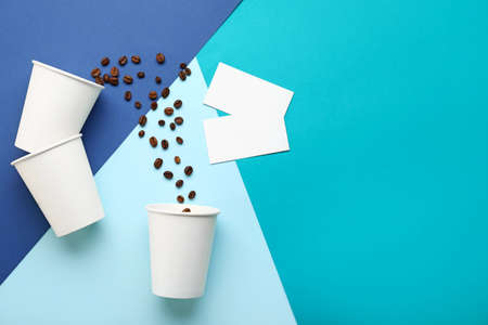 Takeaway coffee cups with business cards on color backgroundの写真素材