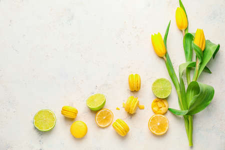 Tasty macarons with citrus fruits on white backgroundの写真素材