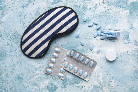 Sleep mask and pills on color backgroundの写真素材
