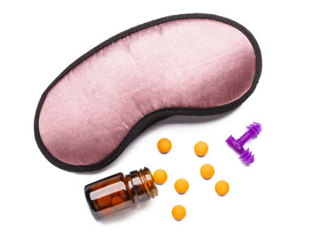 Sleep mask and pills on white backgroundの写真素材