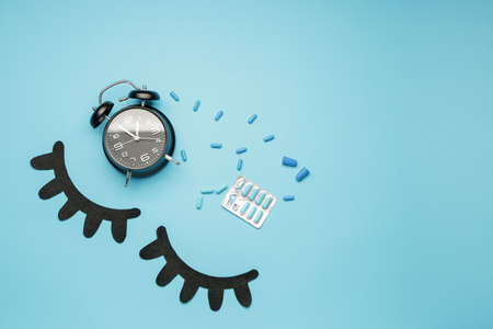 Composition with alarm clock and sleeping pills on color backgroundの写真素材