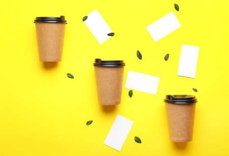 Takeaway coffee cups with business cards on color backgroundの写真素材