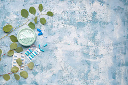 Alarm clock and sleeping pills on color backgroundの写真素材