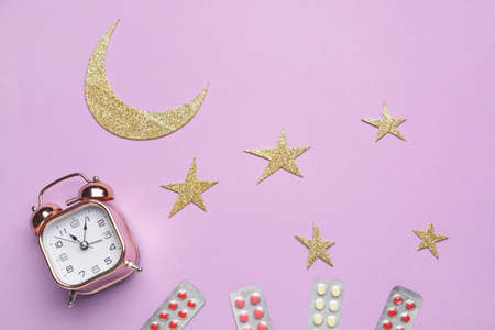 Composition with alarm clock and sleeping pills on color backgroundの写真素材