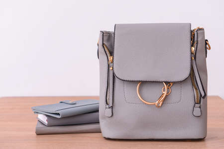 Stylish bag with wallet and notebooks on wooden tableの写真素材