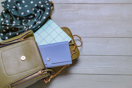 Stylish bag with wallet, notebook and scarf on wooden backgroundの写真素材