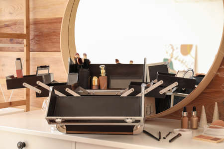Case of professional makeup artist with decorative cosmetics on table