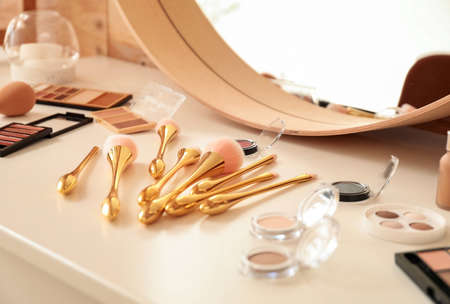 Set of makeup brushes with decorative cosmetics on dressing tableの写真素材