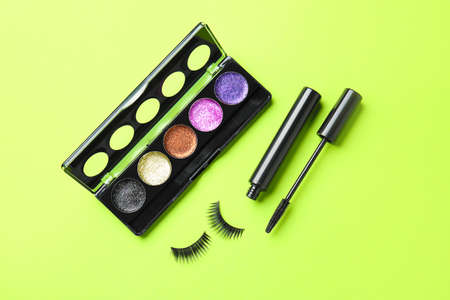 Mascara with fake eyelashes and eyeshadows on color backgroundの写真素材