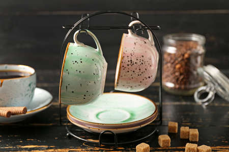 Holder with cups and saucers on kitchen tableの写真素材