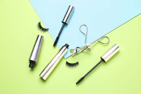 Mascara with fake eyelashes and curler on color backgroundの写真素材