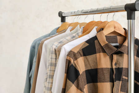 Rack with clothes on light background