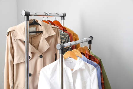 Rack with clothes on light background