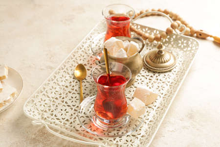 Tray with tasty Turkish tea and sweets on light backgroundの写真素材