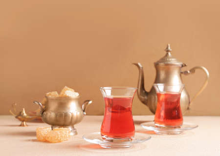 Tasty Turkish tea with sweets on color backgroundの写真素材