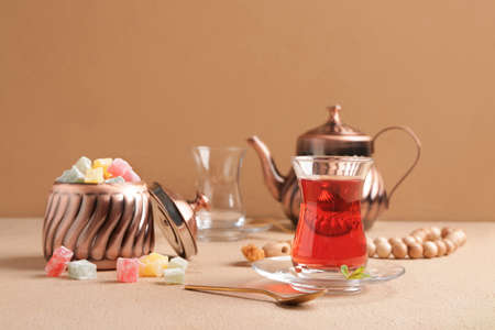 Tasty Turkish tea with sweets on color backgroundの写真素材