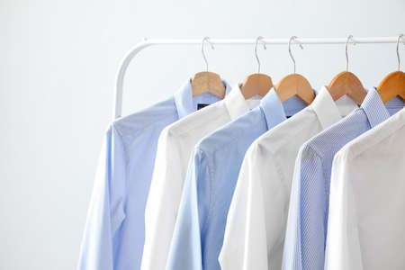 Rack with clothes on light background