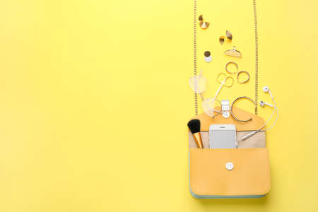 Stylish bag with female accessories and mobile phone on color backgroundの写真素材