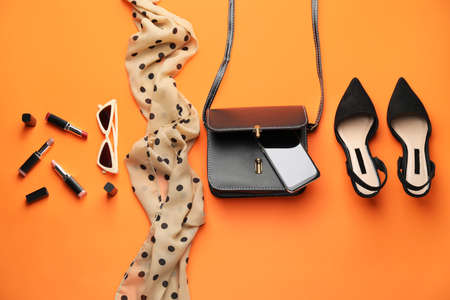 Stylish bag with female accessories and mobile phone on color backgroundの写真素材