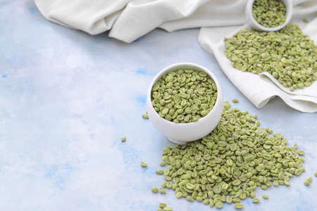 Bowl with green coffee beans on color backgroundの写真素材