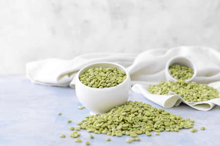 Bowl with green coffee beans on tableの写真素材