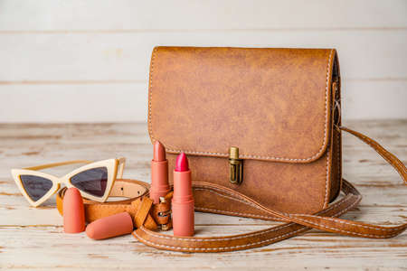 Stylish bag with female accessories on white wooden backgroundの写真素材
