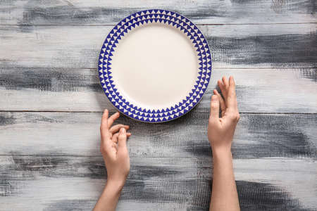 Woman at table with clean plate, top viewの写真素材