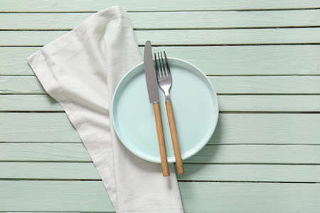 Clean plate and cutlery on wooden backgroundの写真素材