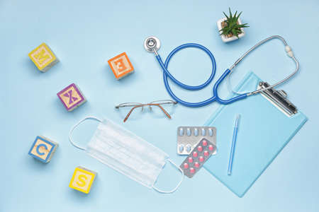 Stethoscope, pills, medical mask and toys on color backgroundの写真素材