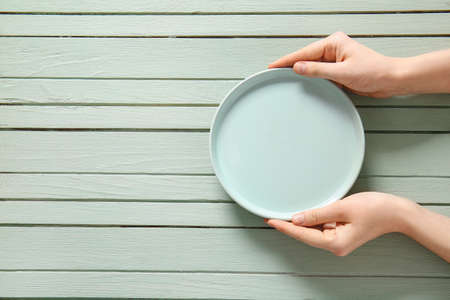 Woman at table with clean plate, top viewの写真素材