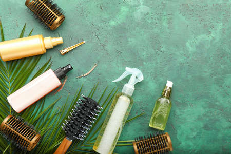 Hair sprays with hairdresser supplies on color backgroundの写真素材