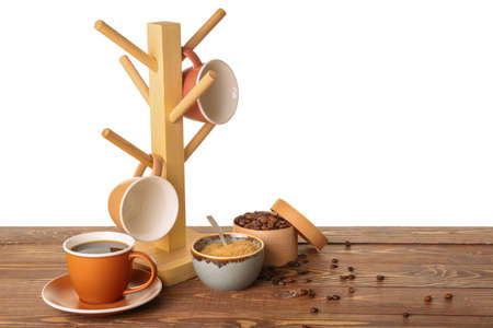 Holder with cups on table against white backgroundの写真素材