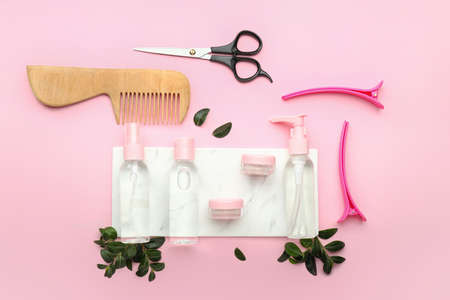 Hair sprays with hairdresser supplies on color backgroundの写真素材