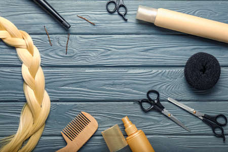 Frame made of hair sprays with hairdresser supplies on wooden background