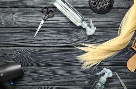 Hair sprays with hairdresser supplies on dark wooden backgroundの写真素材