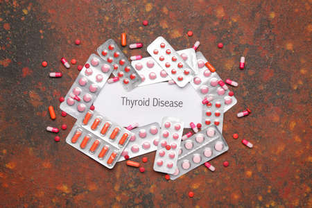 Text THYROID DISEASE with pills on color backgroundの写真素材