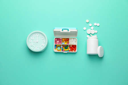 Clock and pills on color backgroundの写真素材