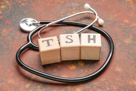 Cubes with abbreviation TSH and stethoscope on color backgroundの写真素材