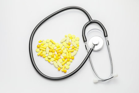Heart made of pills and stethoscope on white backgroundの写真素材