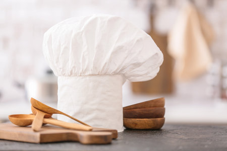 Chef's cap and kitchenware on tableの写真素材