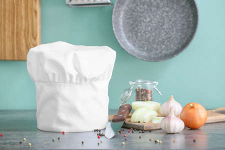 Chef's hat and products on table in kitchenの写真素材