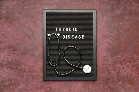 Board with text THYROID DISEASE and stethoscope on color backgroundの写真素材