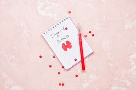 Notebook with drawing of thyroid gland and pills on color backgroundの写真素材