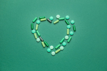 Heart made of pills on color backgroundの写真素材