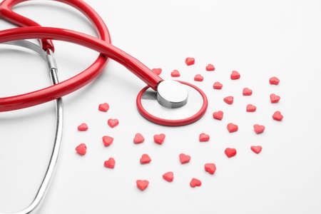 Stethoscope and heart-shaped pills on white backgroundの写真素材