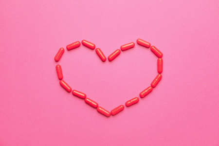 Heart made of pills on color backgroundの写真素材