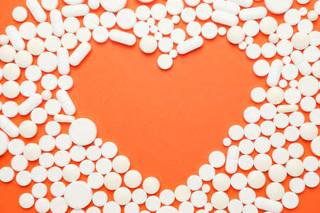 Heart made of pills on color backgroundの写真素材